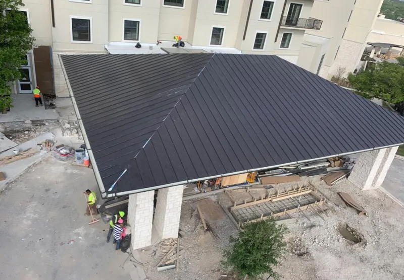 Metal roofing installation team working on a commercial building in San Marcos